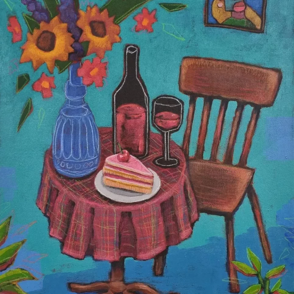A colorful painting of a small round café-style table covered with a red plaid tablecloth. On the table sits a blue decorative vase filled with tall, vibrant flowers, including sunflowers and purple and orange blossoms. Next to the vase is a bottle of red wine, a filled wine glass, and a white plate holding a slice of layered pink cake topped with a cherry. A wooden chair with slatted backrest stands beside the table. The background is painted in bright turquoise, with a small framed abstract portrait hanging on the wall, showing a stylized face in bold colors. Green leafy plants peek in from the corners of the image, framing the scene. The overall style is playful and painterly, with thick outlines and lively, saturated colours.